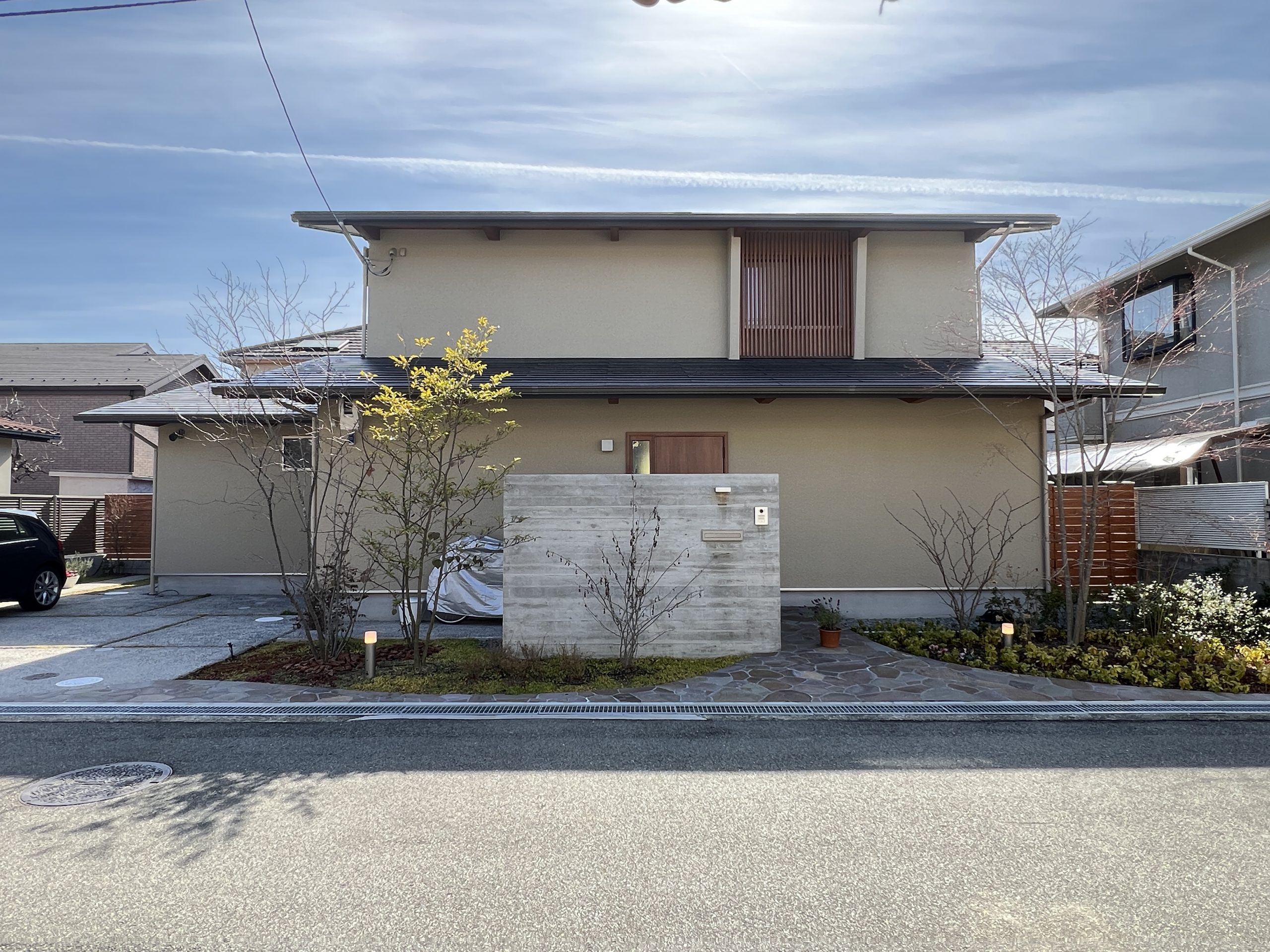 住宅地の中の木々に囲まれた二世帯住宅