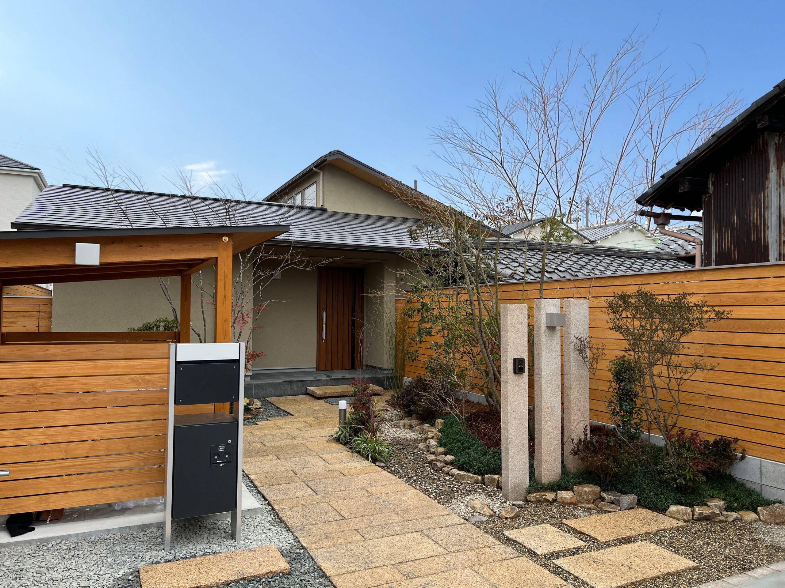 旗竿の敷地に建つお家。屋根付きの駐輪場は外観デザインの一部として設けました。