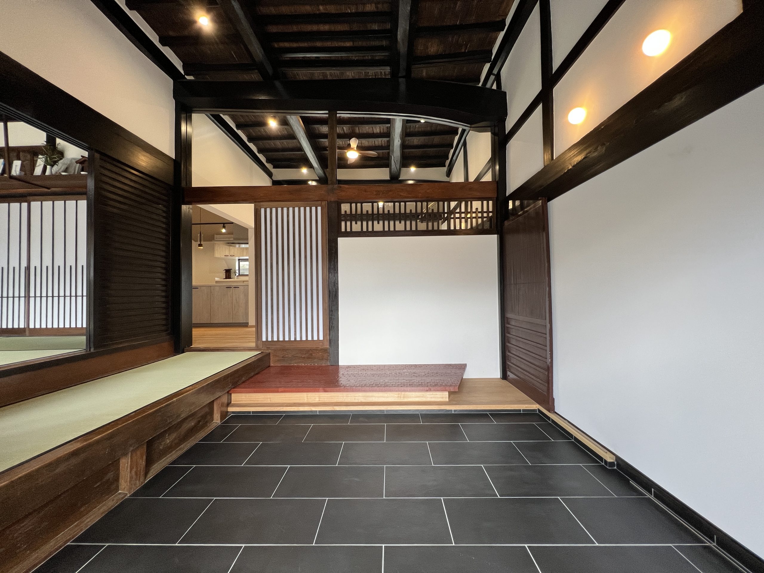 人が集える広い土間空間はそのままに式台を設けて段差を減少させました。リビングと玄関はガラスで空間を仕切っています。
