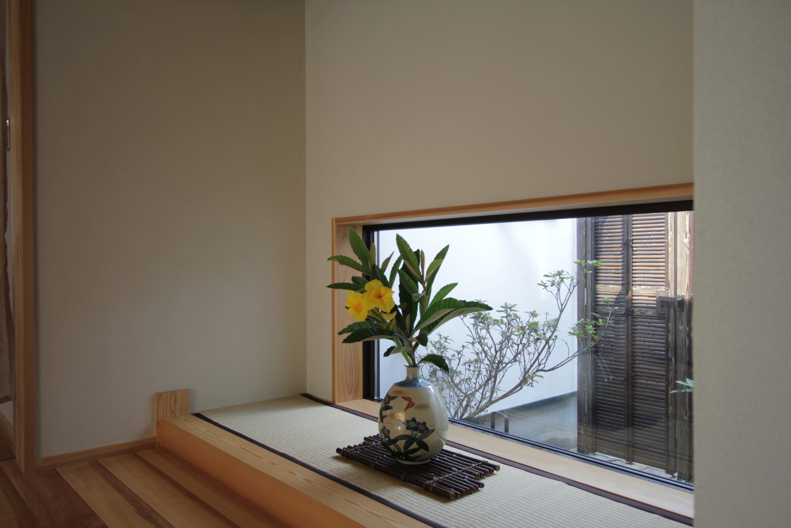 玄関を入ると坪庭がお出迎え。お花を生けることができる畳も設けました。